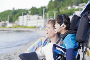 boy with special needs and father smiling outside