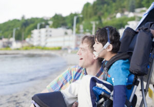 boy with special needs and father smiling outside