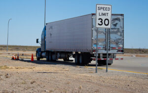 truck stopped on side of road with speed limit sign
