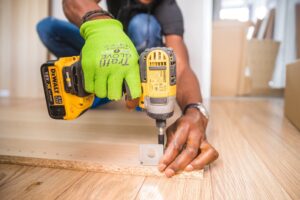 construction worker using dewalt drill on brown board
