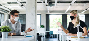 masked coworkers socially distancing
