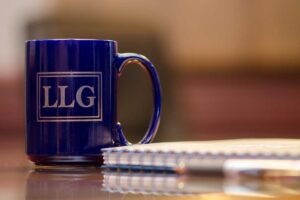 blue and gold coffe LLG mug on table with notebook